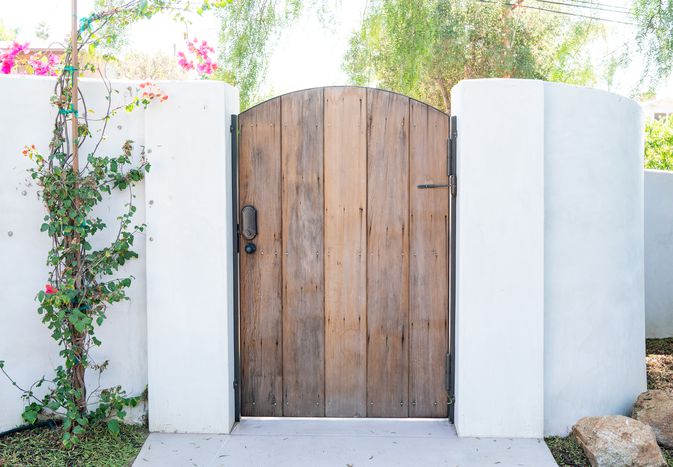 High white wall with a simple natural wood gate door
