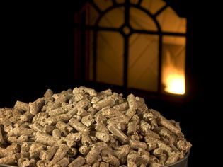 Wood pellets with pellet stove lit in the background