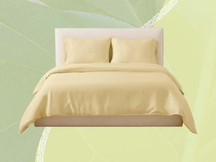 A bed with yellow bedding on a green background