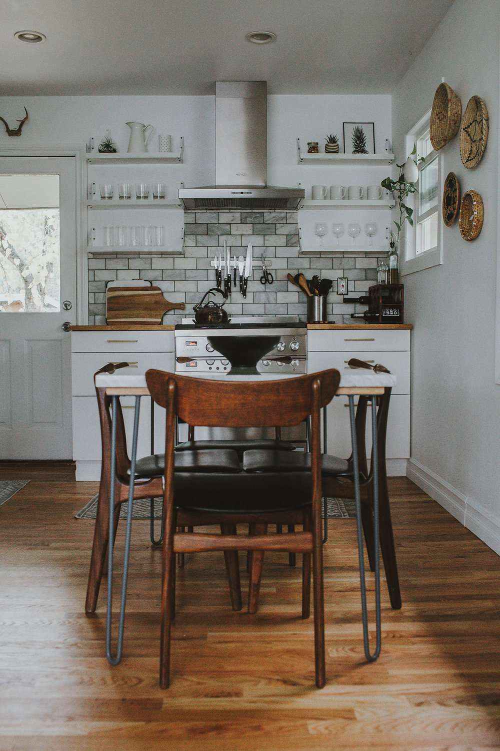 kitchen with white tile backsplash and rustic kitchen table
