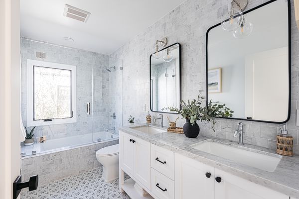 Large bathroom with double vanity and patterned tile flooring