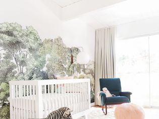 Modern clutter-free nursery with white crib and standing stuffed zebra