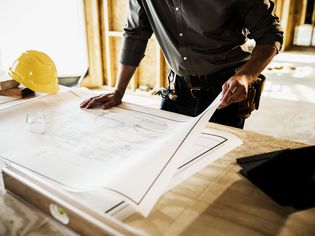 Building contractor reviewing blueprints