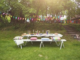 Buntings hanging over food served on decorated picnic table at back yard