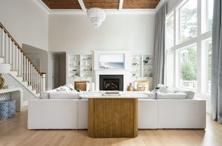 Large living room with a white sectional and sofa table.