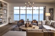 A neutral brown and gray living room with a view of water. The room follows the 60-30-10 rul