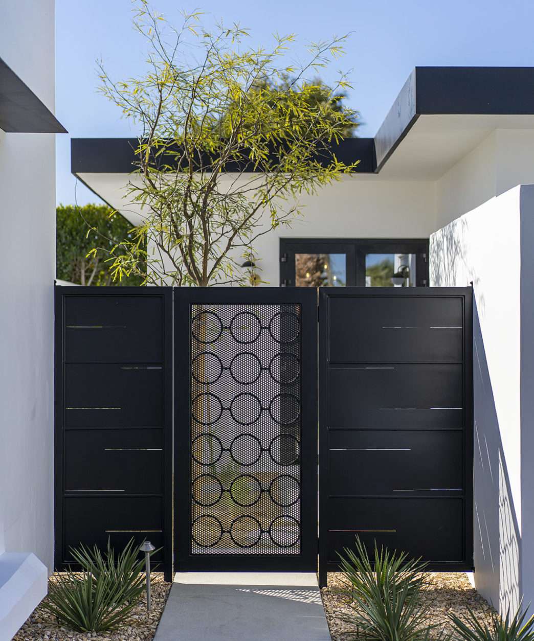 Black and white house with a flat roof and black gate