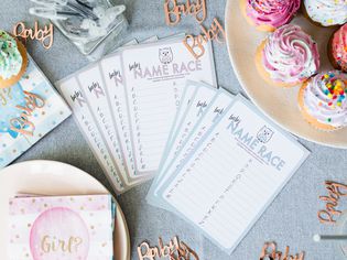 Baby Name Race printouts on decorated table for gender reveal party