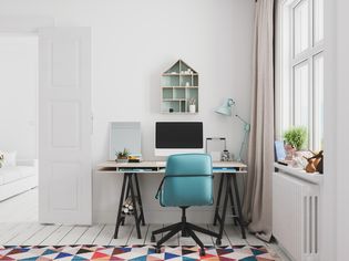 home office interior with colorful rug and blue chair