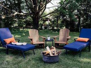 Adirondack chairs and loungers next to a fire pit