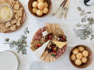 Party food laid out on decorative table with eucalyptus