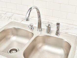 Delta kitchen faucet installed with surrounding marble countertop