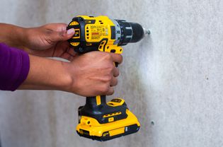 Yellow electric drill installing cement board