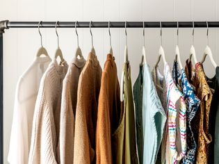 Black DIY clothing rack with sweaters and blouses organized on hangers