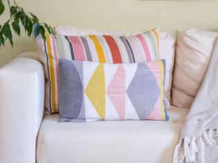 Colorful patterned and striped throw pillows on white couch