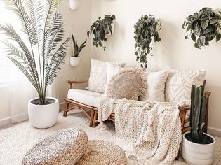 Faux plants throughout this living room with a neutral boho decor