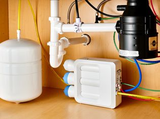 Reverse osmosis water filtration system connected to garbage disposal under sink