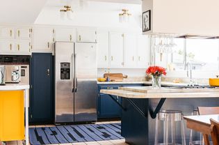 Brightly-lit kitchen with blue and white painted cabinets