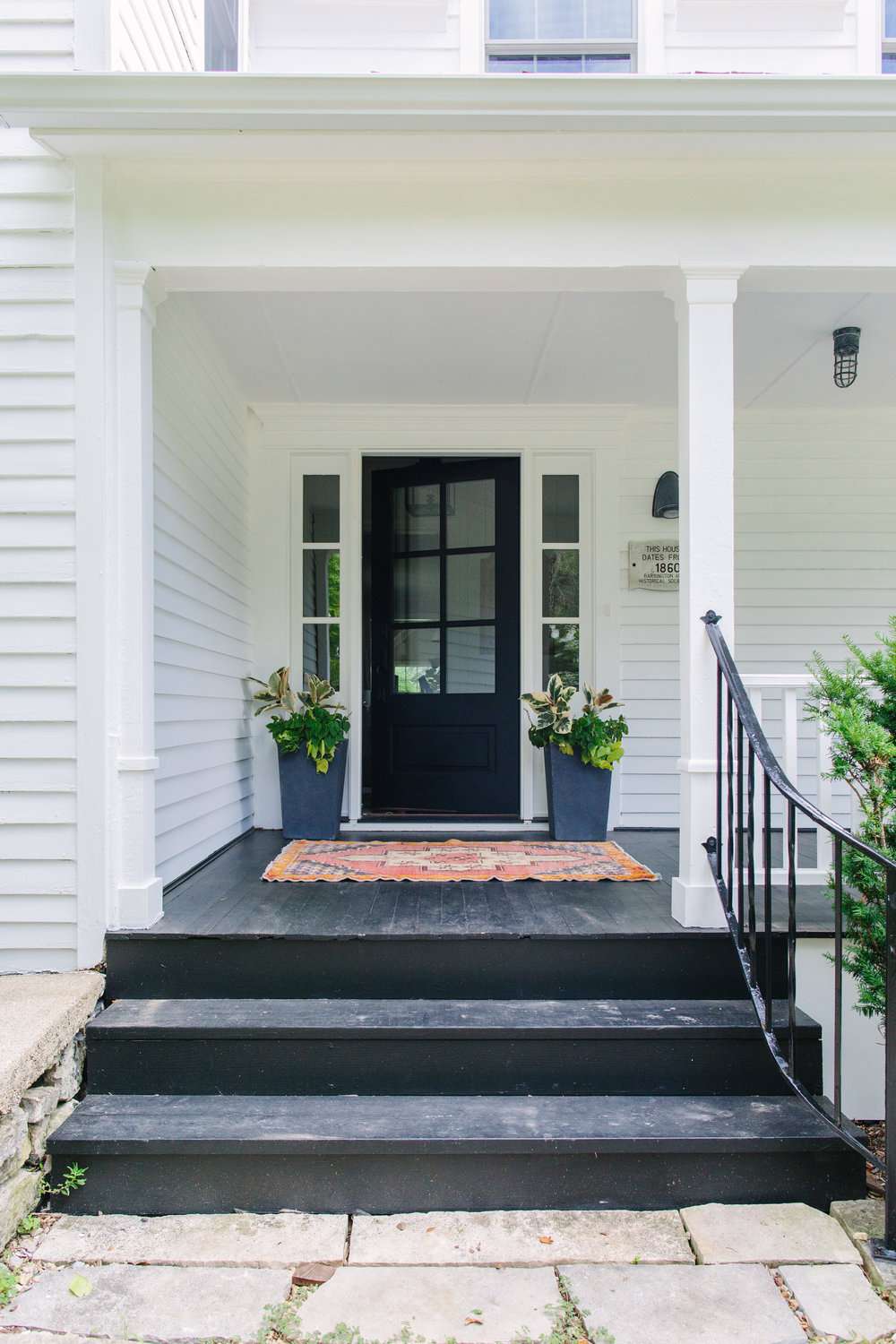 White house with black door and black painted porch and stairs