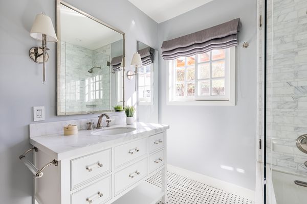 Large bathroom with square mirror over marble vanity top
