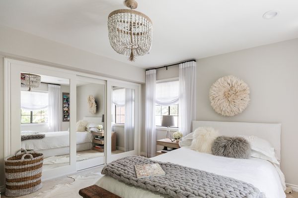 Primary bedroom with nontraditional chandelier light hanging in center of ceiling