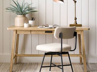 Mateo rustic desk displayed against a white wall with a lamp, plant, and magazine
