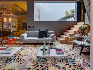 Living room with colorful rugs by Olga Hanono