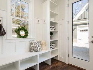 White and organized mudroom with window and windowed door
