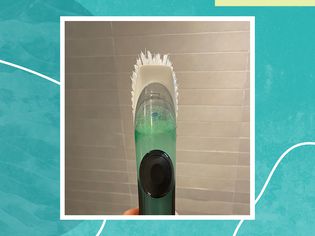 standing scrub brush filled with dish soap and vinegar for a testing of a viral TikTok shower-cleaning hack