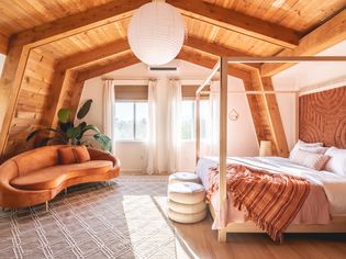 Pulled out view of a barn apartment with a canopy bed and velvet sofa