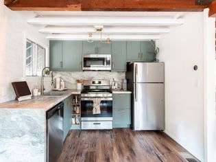 Front view of a remodeled small kitchen with sage green cabinets