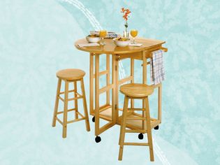 Winsome Space Saver With 2 Round Stools displayed against a two-tone blue patterned background 