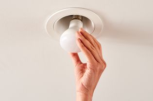 Closeup of a hand finishing installing recessed lighting