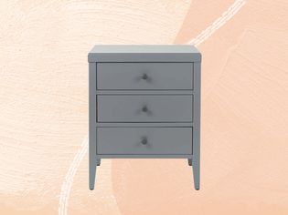 A grey Andover Mills Rushville Wood Nightstand displayed on a two tone pink background