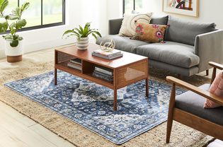 A blue patterned rug layered on top of a hemp jute rug