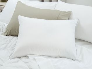 Multiple down pillows sitting on white bedsheets