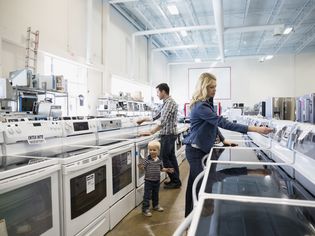 Young family shopping for stoves in an appliance store